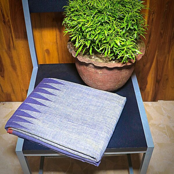 Blue Handloom Saree With Temple Design folded and kept on a chair